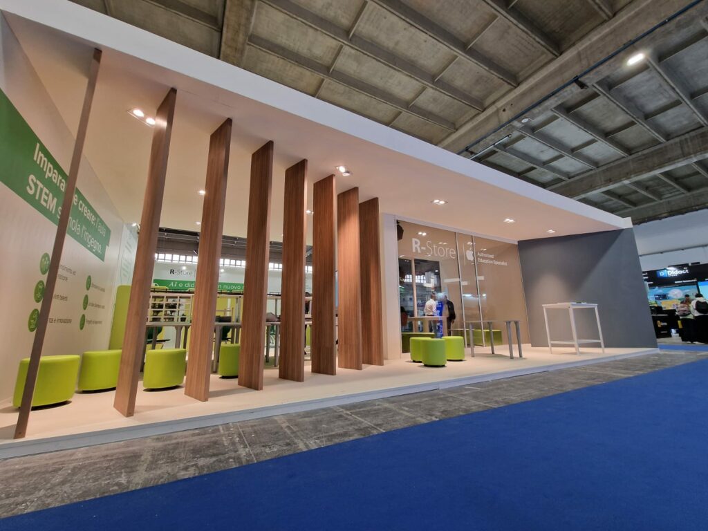 "Stand fieristico R-Store a Didacta 2024 Bari - Design moderno con elementi verdi e tecnologici integrati, vista frontale dell'allestimento personalizzato