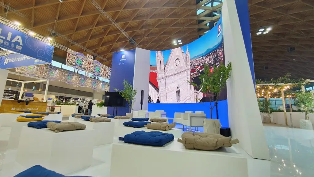 Stand Campania Divina della Regione Campania al TTG Travel Experience 2024 con allestimento verde, ledwall e tecnologie avanzate